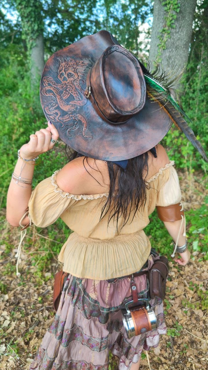 Full view of a pirate-style leather hat with a decorative buckle and customizable engravings, this one is brown with chtulhu / octopus engraving!