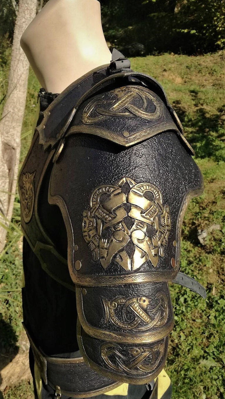 A stunning black and gold leather pauldron with a hand-engraved wolf motif, perfect for medieval and fantasy warriors. The layered design provides enhanced mobility, while the secure strap system ensures a comfortable and adjustable fit. Ideal for reenactments, cosplay, and LARP