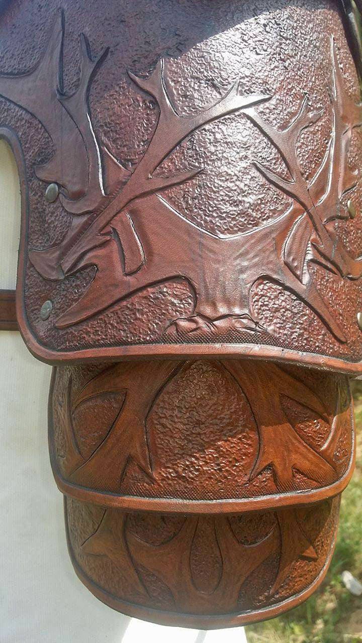 A classic brown leather pauldron with hand-tooled engravings and reinforced stitching. Designed for medieval warriors and fantasy characters who need durable and stylish protection