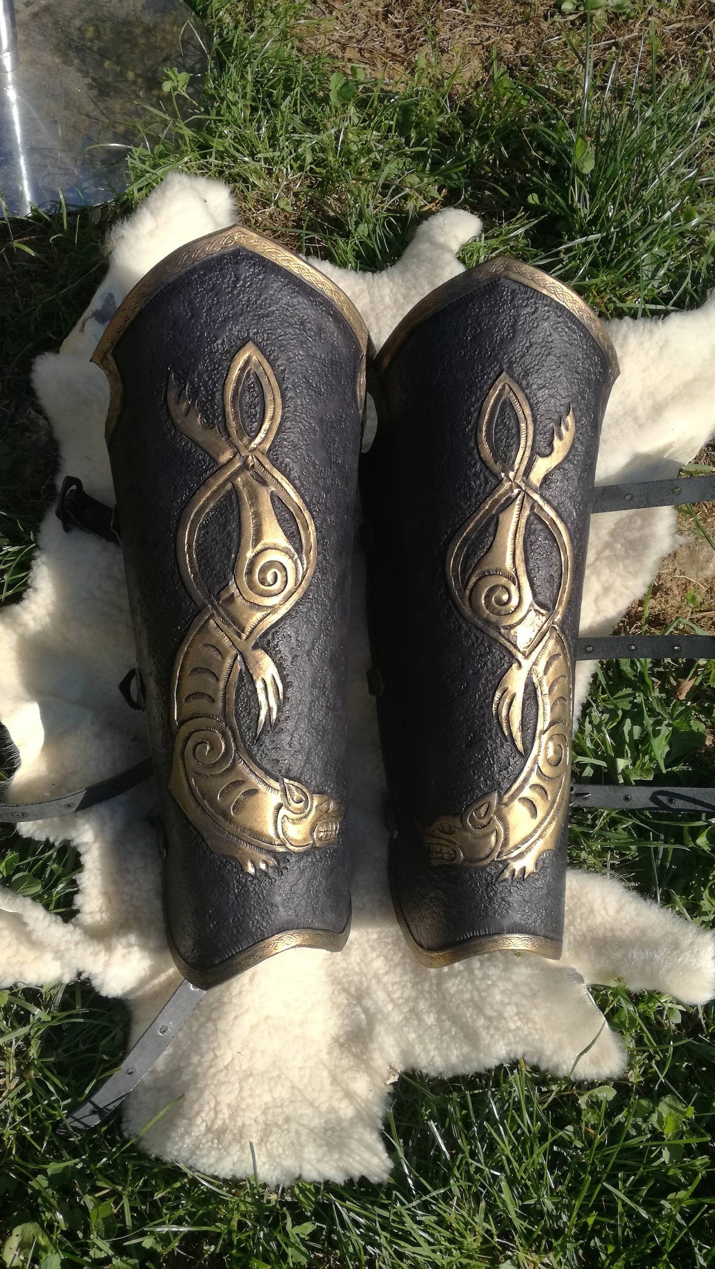 This black and gold knight-style bracers and greaves showcases a majestic engraved celtic wolf, crafted from durable leather. The elegant gold accents elevate the look, making it a premium choice for cosplay knights, medieval reenactors, and LARP warriors