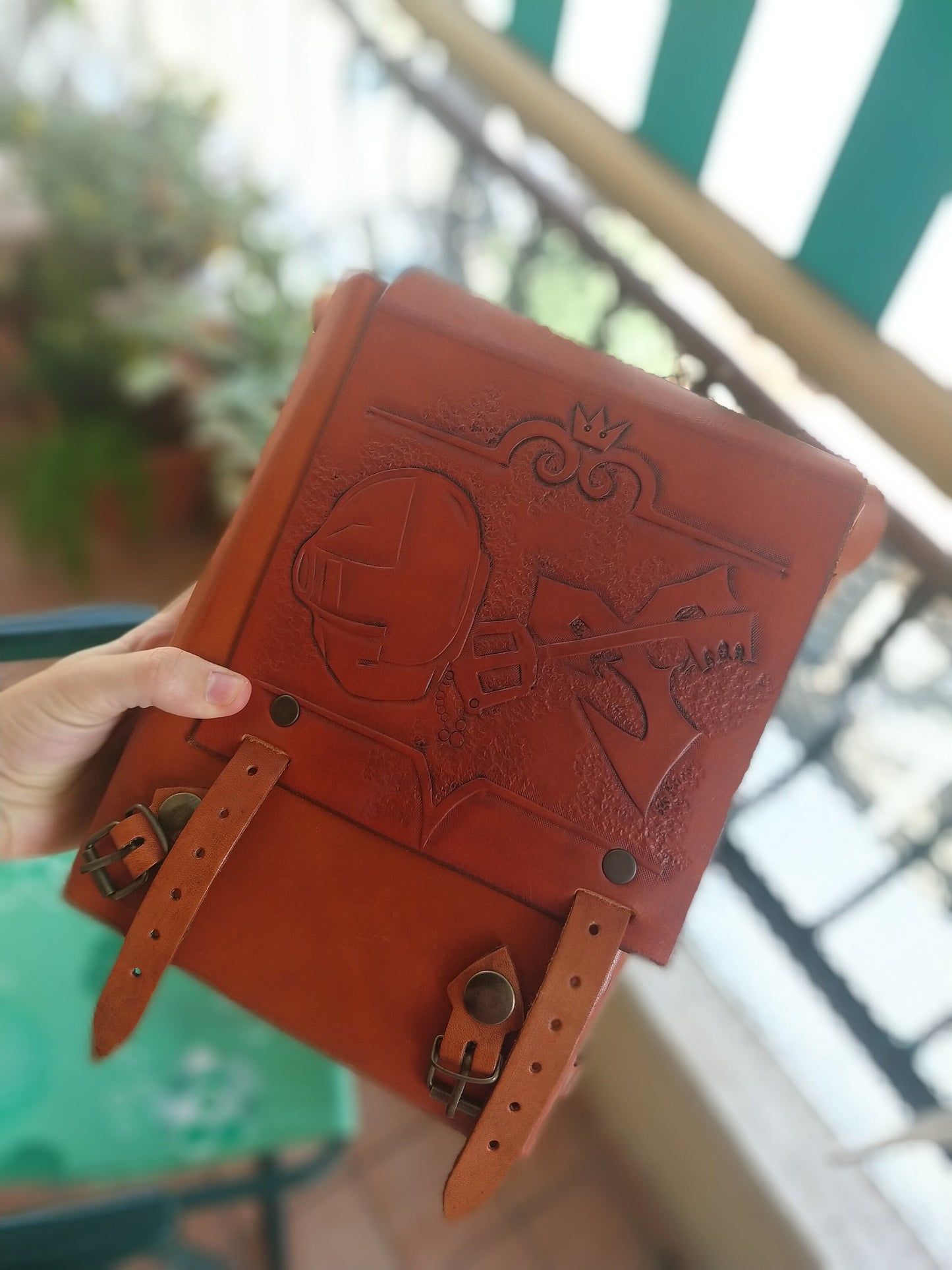 A custom size (small, medium, large) handcrafted leather bag with nature-inspired engravings, customizable in color and design for a unique personal touch.