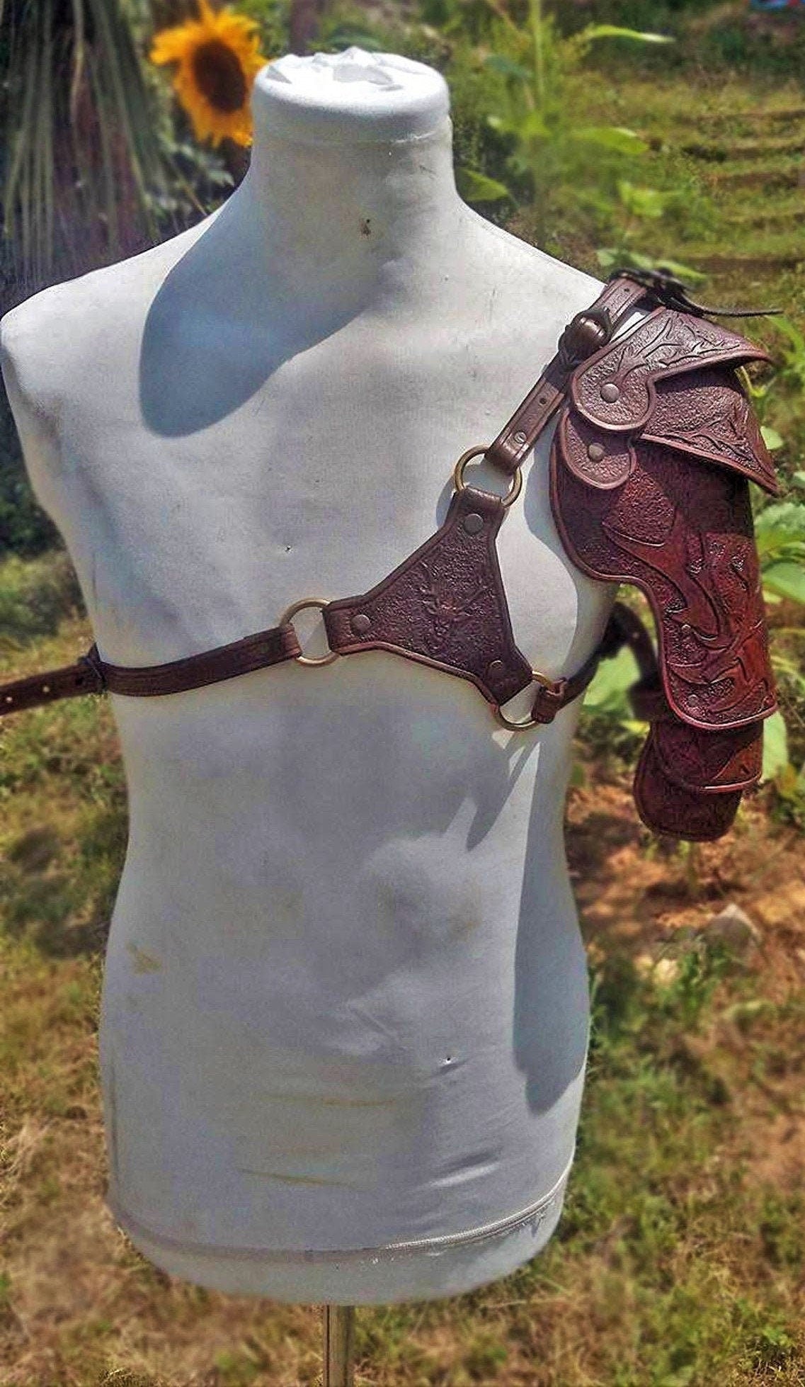 A light brown leather spaulder with hand-engraved deer, perfect for explorers and medieval adventurers. Made with care and precision for LARP and theatrical use.