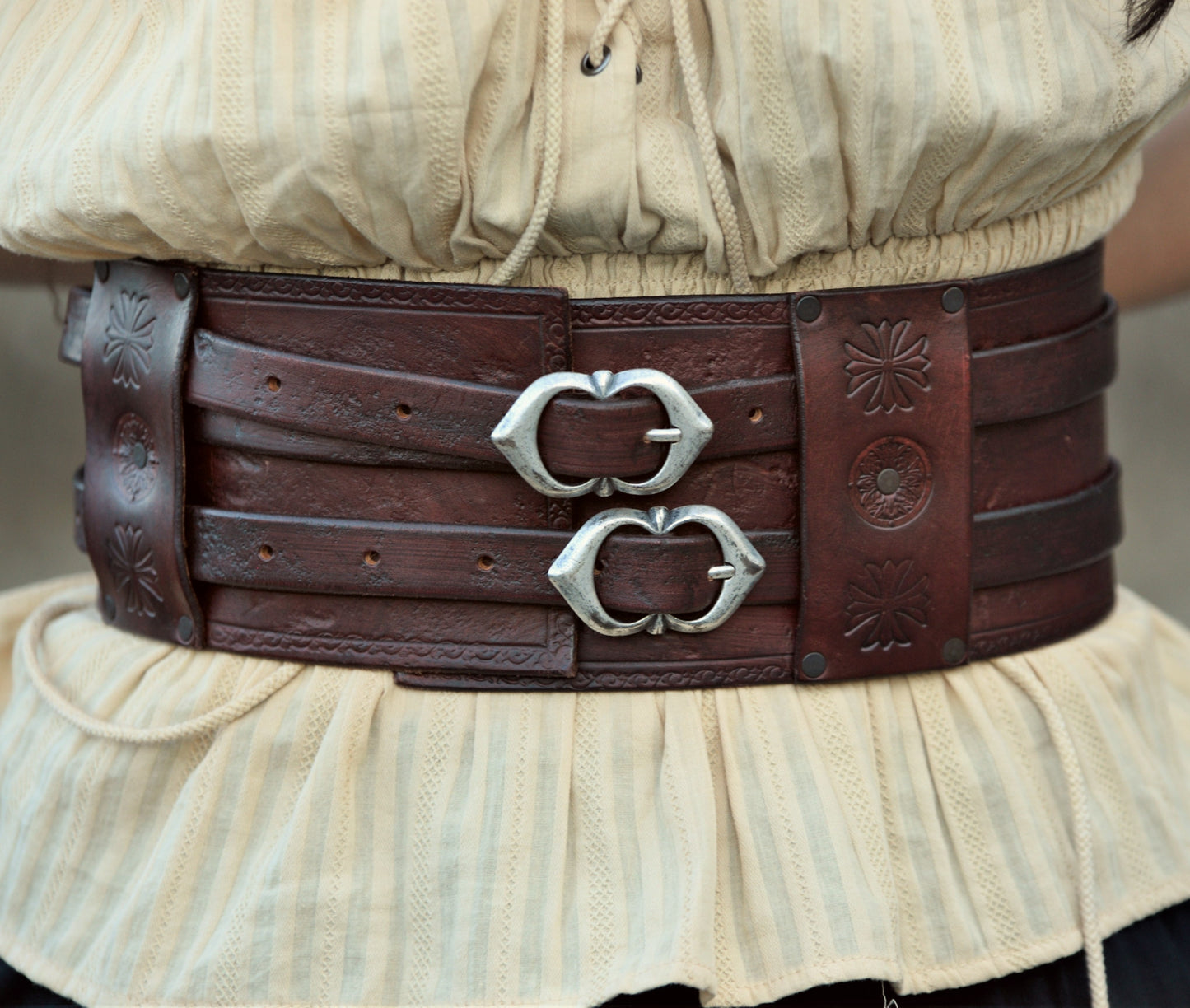 A double buckle leather belt made by skilled artisans. Available in brown, beige, and black, with optional Celtic decorations