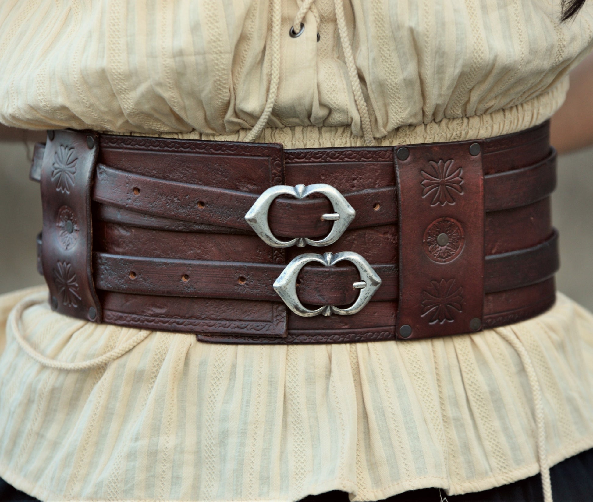 A double buckle leather belt made by skilled artisans. Available in brown, beige, and black, with optional Celtic decorations