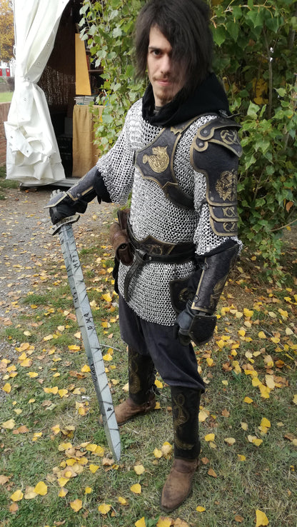A beautifully engraved black and gold leather armor, complete with shoulder guard, belt, tassets, bracers and greaves with a fierce wolf design. Handcrafted from genuine leather, this piece is ideal for fantasy warriors, LARP fighters, and theatrical performances. The adjustable straps provide a secure and comfortable fit.