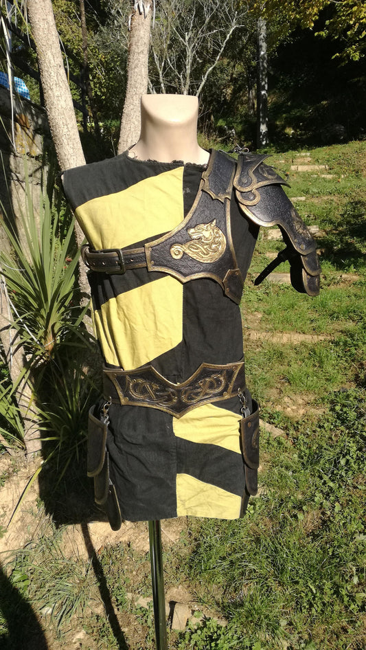 A handcrafted black and gold leather armor featuring an intricately engraved wolf design. Made from premium vegetable-tanned leather, this shoulder armor offers durability, flexibility, and a bold battle-ready aesthetic. Fully customizable with engraving, color, and size options, making it ideal for LARP, cosplay, and medieval fantasy costumes