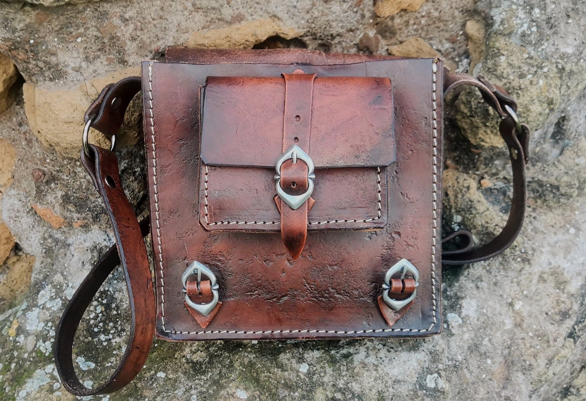 Fantasy-inspired leather shoulder bag with medieval-style engravings, adjustable strap, and durable handcrafted design