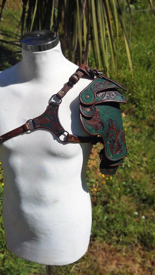 A pair of green and brown handcrafted leather spaulders, ideal for fantasy adventurers. Designed for comfort and movement, these engraved shoulder guards bring authenticity to any LARP or cosplay outfit. Fully customizable in color and design.