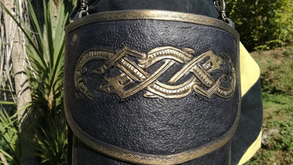 Detail of a tasset of the complete black and gold armor, meticulously handcrafted with a striking engraved wolf design. Made for medieval fantasy characters, this fully adjustable armor piece adds both protection and style to any warrior’s ensemble