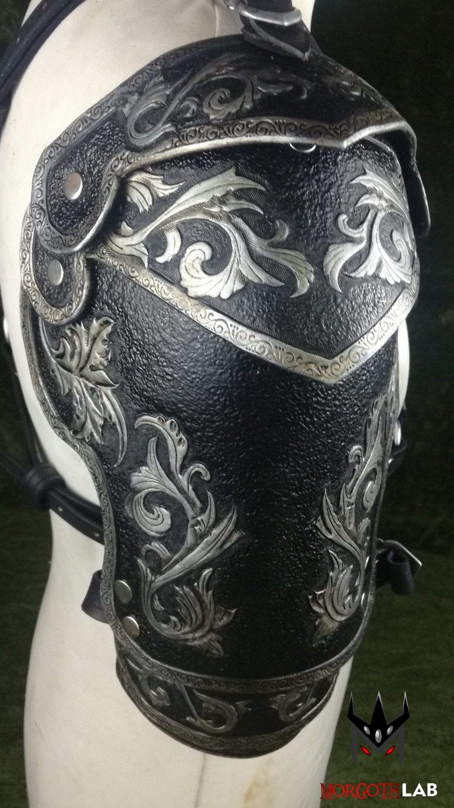 A sophisticated black and silver leather pauldron, designed for knights, warriors, and elite fantasy characters. The engraved patterns and fine craftsmanship add an air of nobility, making it perfect for high-class LARP costumes.