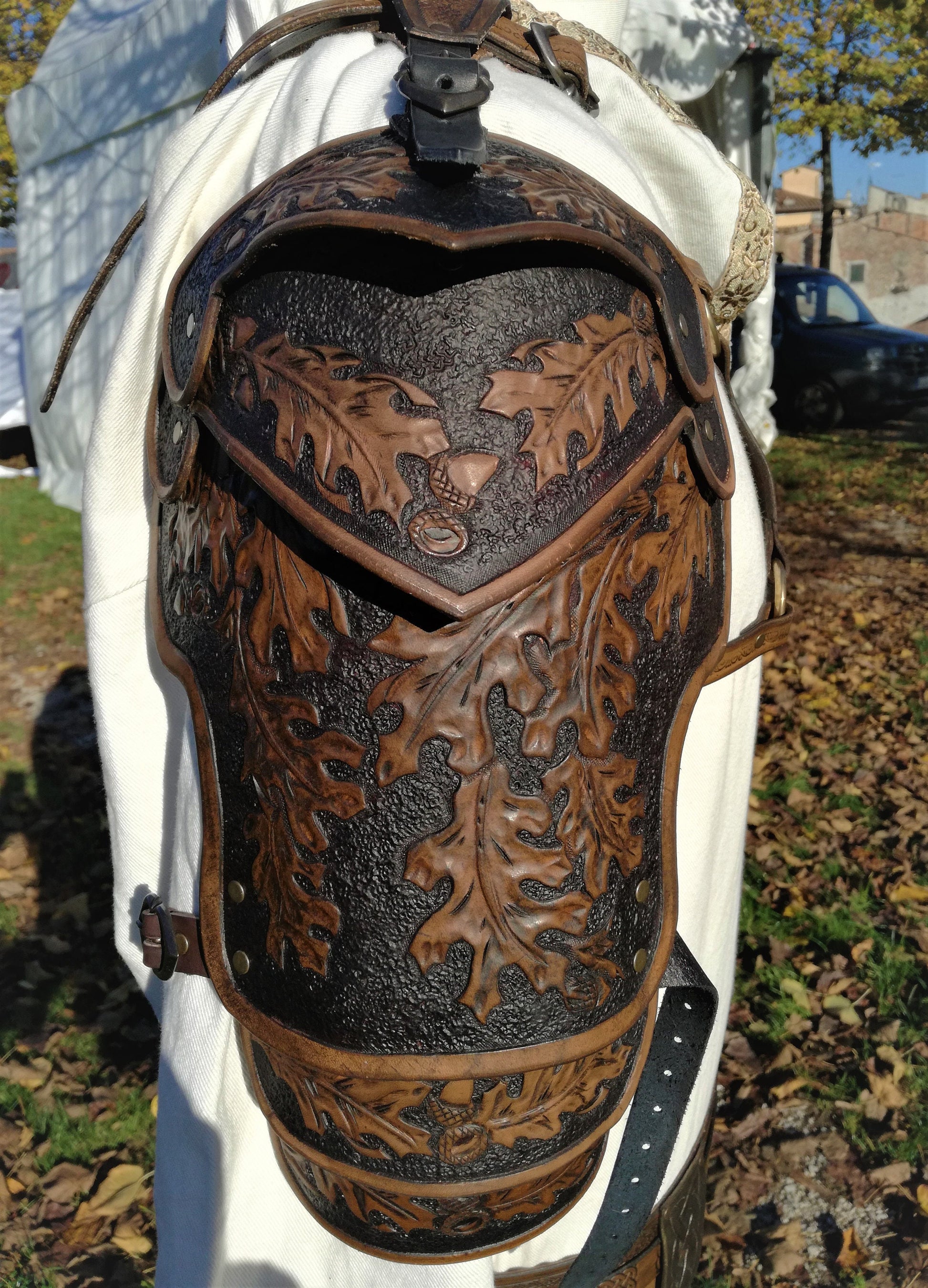 A light brown leather spaulder featuring hand-engraved oak leaves, symbolizing strength and endurance. The flexible and adjustable design makes it ideal for medieval fantasy role-playing, theater, and cosplay
