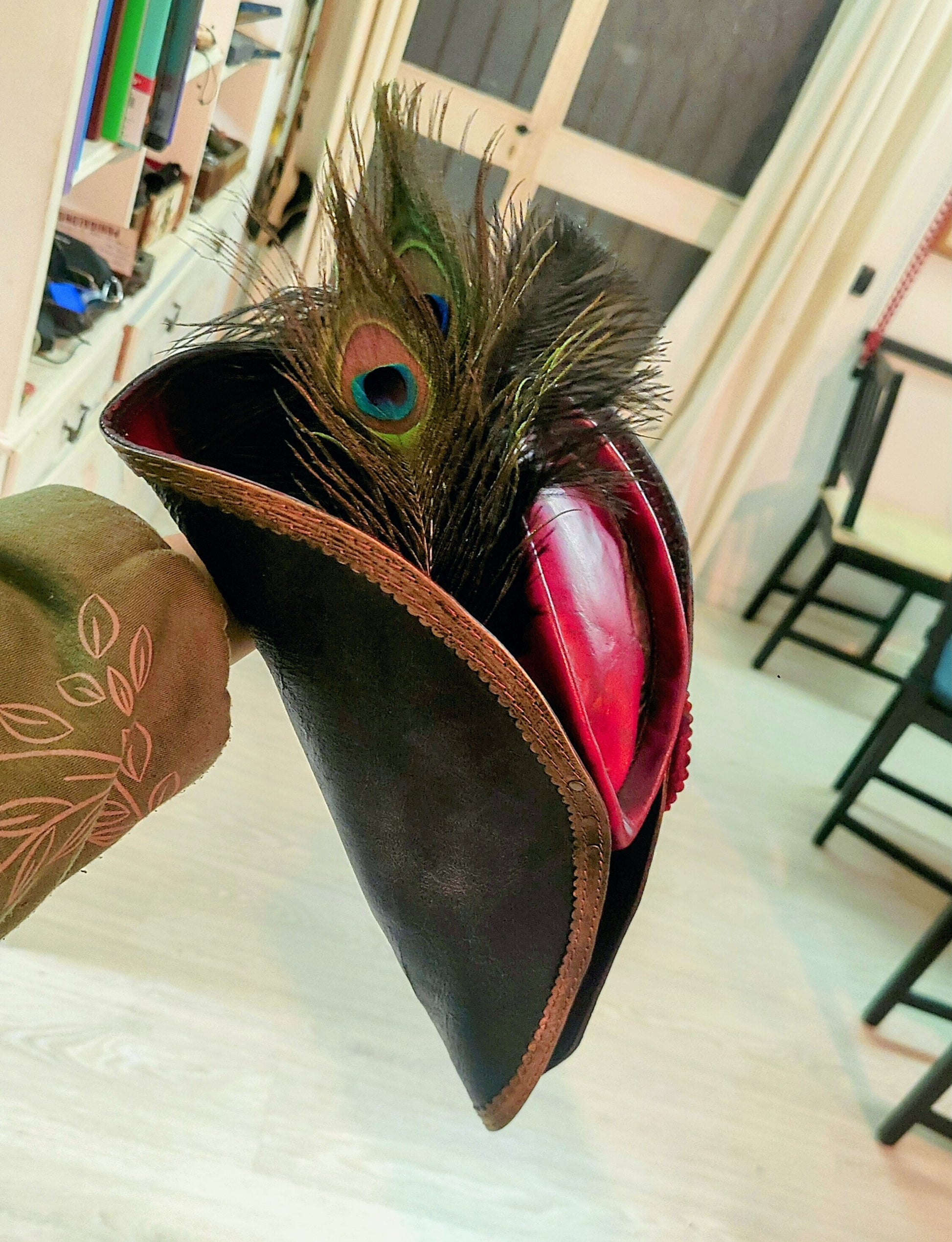 side/back view of the leather hat, focusing on the decorative peacock feathers