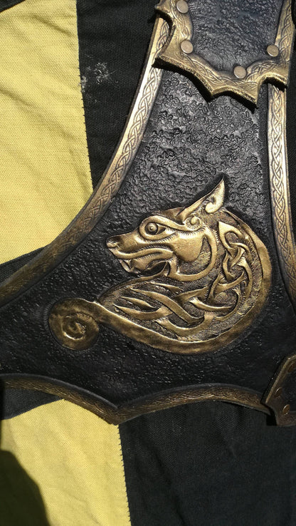 A handcrafted black and gold leather spaulder featuring an intricate engraved wolf design. Made from high-quality Italian vegetable-tanned leather, this shoulder armor is designed for warriors, knights, and adventurers. The overlapping plates provide excellent flexibility, while the secure double-strap system ensures a comfortable fit. Fully customizable with engraving, color, and size options, this pauldron is perfect for LARP, cosplay, and medieval fantasy costumes